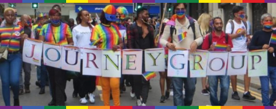 Journey members marching in Birmingham Pride parade holding a banner saying 'Journey Group'