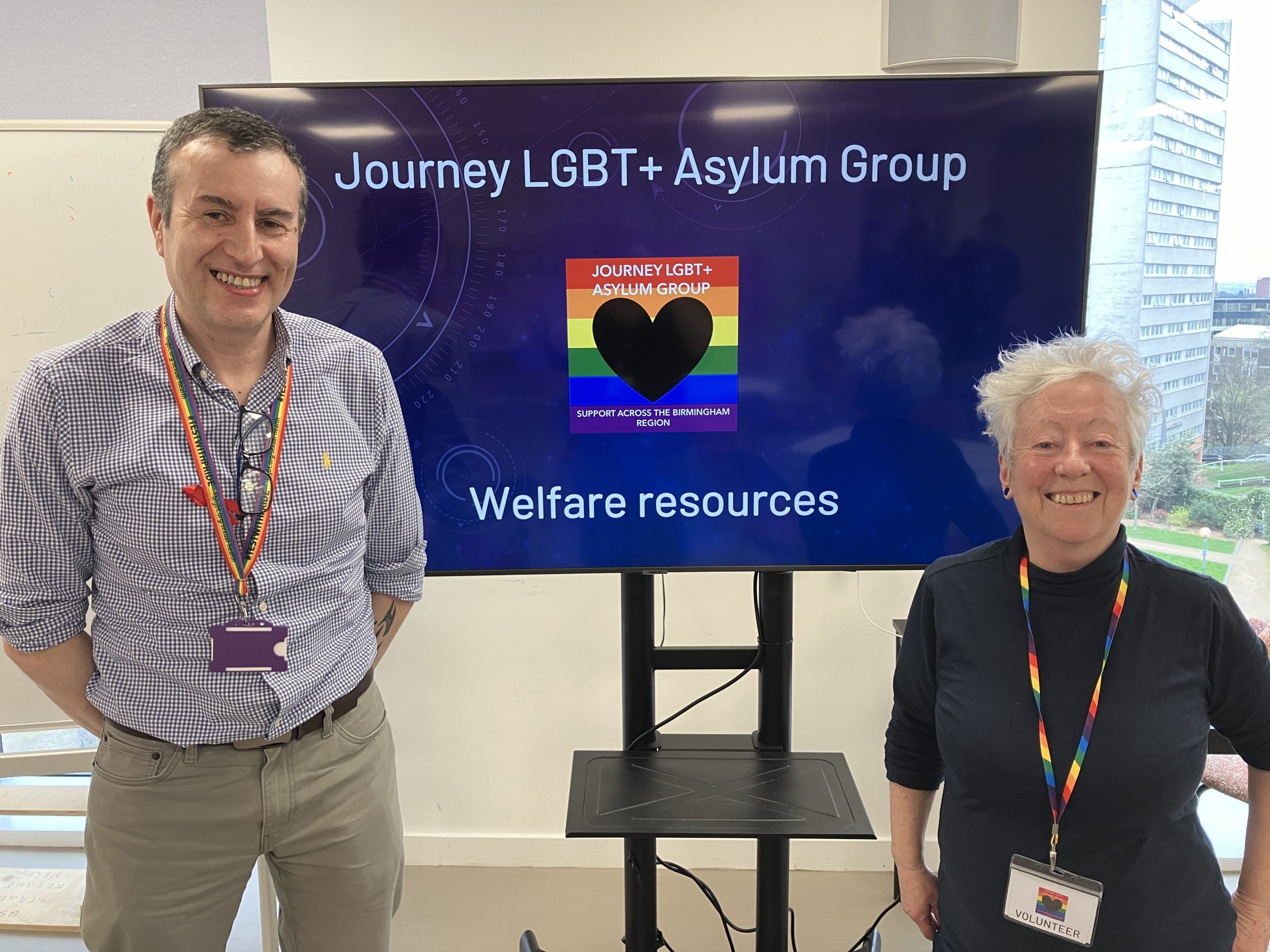 Nigel and Sheila standing next to a screen displaying the Journey logo and the title 'Welfare resources'